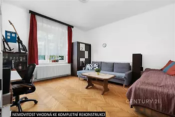Světlý obývací pokoj s parketovou podlahou, velkým oknem a prostorným uspořádáním. Vhodný pro rekonstrukci dle vlastního vkusu.