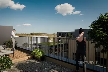 Prostorná terasa s moderním zábradlím, dřevěná podlaha, výhled na zelenou střechu a zahradu, ideální pro relaxaci