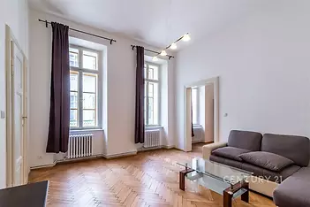 Prostorný obývací pokoj, parketová podlaha, velká okna, moderní design, světlý interiér, ideální pro rodinné bydlení.
