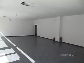 Světlý obývací prostor s dlažbou, velkými okny a moderními stropními rozvody, ideální pro otevřený design interiéru