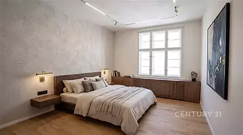 Prostorná ložnice s parketovou podlahou, velkými okny a moderním designem nabízí útulný a světlý prostor pro relaxaci