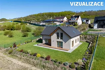 Rodinný dům s moderní fasádou, dřevěnou terasou a pečlivě udržovanou zahradou, obklopený přírodou a klidnou lokalitou.
