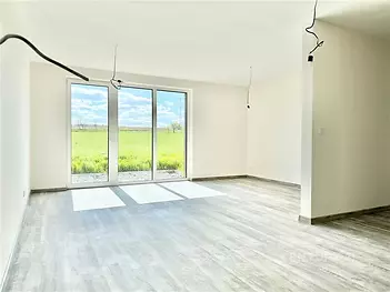 Světlý obývací pokoj s velkými okny, moderní parketová podlaha, výhled na zahradu, nově zrekonstruovaný, minimalistický styl.