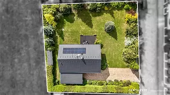 Letecký pohled na zahradu s moderním domem, solární panely, střešní tašky, udržovaný trávník, přírodní prostředí, klidná lokalita.