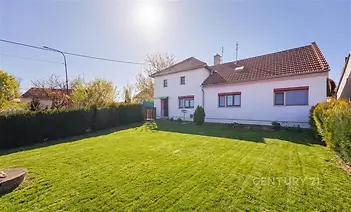 Rodinný dům s velkou zahradou, tradiční střešní krytina a bílá fasáda, klidná lokalita, slunný pozemek, prostorný dvorek.