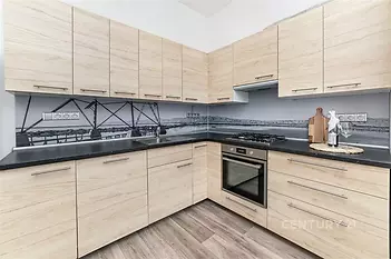 Moderní kuchyň s dřevěnou pracovní deskou, vestavěnými skříněmi a parketovou podlahou, světlé dřevo a elegantní design zajišťují atraktivitu.