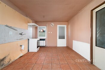 Kuchyň s dlažbou, k rekonstrukci, se staršími spotřebiči a velkými okny, prostorná s možností modernizace, příprava na vestavěné skříně.