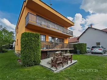 Dvoupatrový rodinný dům s dřevěným balkonem, zahrada s dřevěnou terasou, možnost parkování, klidná rezidenční oblast.