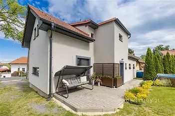 Rodinný dům s terasou, moderní fasádou a zahradou. Kvalitní venkovní dlažba, světlé omítky, udržovaná zeleň a klidná rezidenční lokalita.
