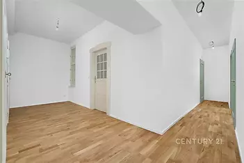 Prostorná chodba s parketovou podlahou, nově vymalované stěny, dřevěné dveře, moderní design interiéru.
